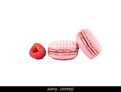 Two pink macaroons and raspberry isolated on a white background. Sweet macaroons. French dessert macaroons. Copy space. Stock Photo