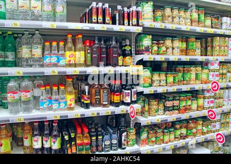 Canned mushrooms and vinegar on shelves of supermarket store. Canned food products in supermarket. Canned food on store shelves. Preserved Stock Photo