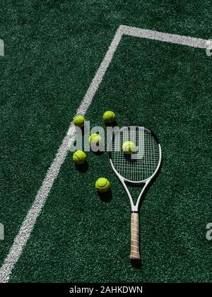Tennis court Top view Six tennis balls and racket on the green grass ...