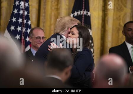Washington, District of Columbia, USA. 13th June, 2019. U.S. President Donald Trump embraces outgoing White House Press Secretary Sarah Huckabee Sanders as delivers remarks about prison reform in the East Room of the White House in Washington, DC on June 13, 2019. Sanders announced today that she will be leaving the White House at the end of the month. Credit: Alex Edelman/ZUMA Wire/Alamy Live News Stock Photo