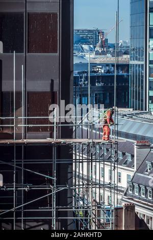 Construction workers on a high scaffold on a building site in central London, UK Stock Photo