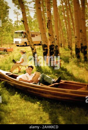 A couple is enjoying reading under a tree. Stock Photo