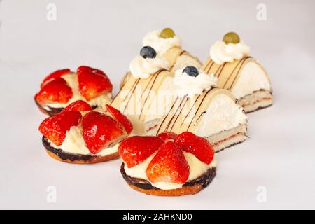 Strawberry cakes with fresh strawberries and Danish Whipped Cream Cake with puff pastry, vanilla cream, marzipan, whipped cream and blueberry. Selecte Stock Photo