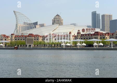 View across the Haihe river to the riverside of Binhai Free Trade Zone, Tianjin, China, with Haicheng Polar World building prominent in the foreground Stock Photo