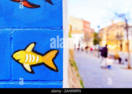 A nice little fish drawn with paint in the corner of a wall in a street. Stock Photo