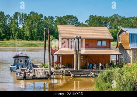 Delta, B.C., Canada - July 20, 2019. Floating homes moored on the Fraser River, a housing alternative growing in popularity as real estate prices rise Stock Photo