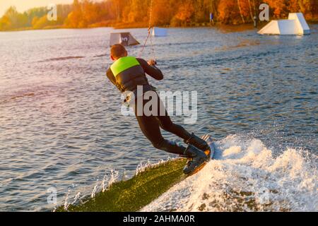 Wakeboarder making tricks. Low angle shot of man wakeboarding on a lake Stock Photo