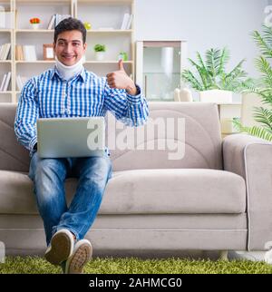 The man freelancer in a cervical collar neck brace working from home Stock Photo