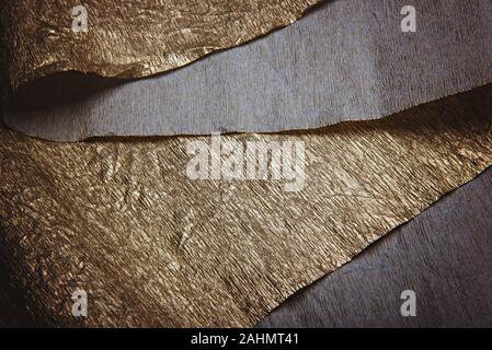 Golden texture. Gold leaf corrugated wrapping paper on the classic blue background. Stock Photo