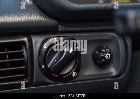 Close-up on the headlight switch control buttons and automatic adjust level dashboard in retro old car in the vehicle repair workshop. Auto service in Stock Photo