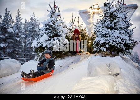 Finnish Rovaniemi a city in Finland and the region of Lapland Santa Park William on a plastic sledge Stock Photo