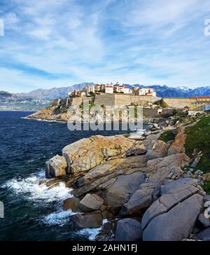 Calvi Citadel and Old city seen from Revellata Peninsula, Coast Rocks are at foreground, Balagne, Haute-Corse, France Stock Photo