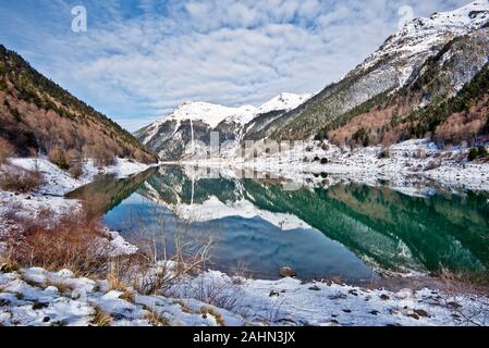 Winter picture of Pyrenean Fabreges Lake in Ossau Valley. The Sagette mounting is at background, Mountain landscape reflecting in water mirror. Bearn, Stock Photo