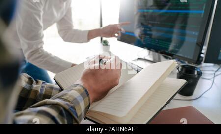 Young startup Programmers Sitting At Desks Working On Computers screen for Developing programming and coding to find solution to problem on New Applic Stock Photo