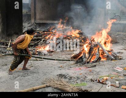 PURI,ODISHA/INDIA-MARCH 12 2018:A worker tends the pyre of a Hindu person at Swargadwar crematorium next to the main beach.A steady flow of corpses ar Stock Photo
