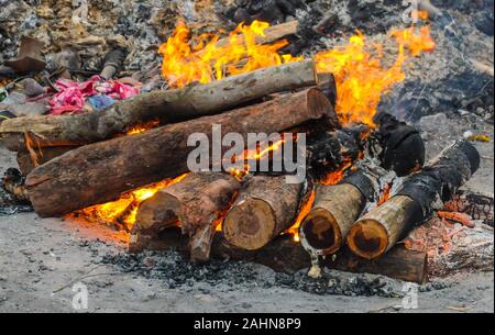 The body of a Hindu person is being cremated in the traditional way and,surrounded by similar pyres the intense heat,smoke and odors are overwhelming. Stock Photo