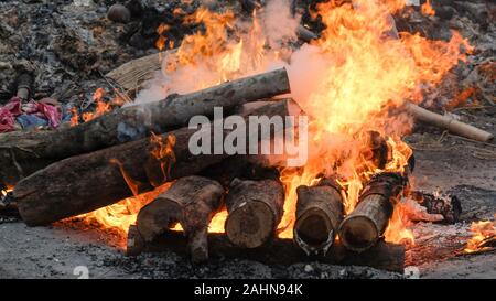 The body of a Hindu person is being cremated in the traditional way and,surrounded by similar pyres the intense heat,smoke and odors are overwhelming. Stock Photo