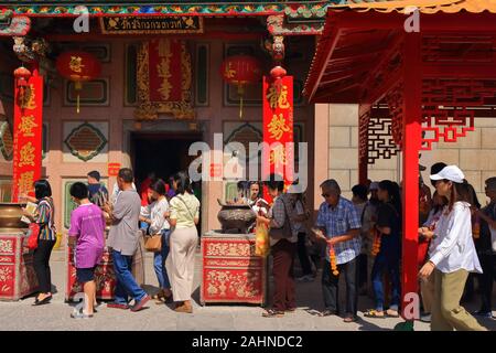 Bangkok, Thailand - December 31 2019 : Tourists lighting joss sticks and put into incense burner to worship Buddha and making wishes Stock Photo