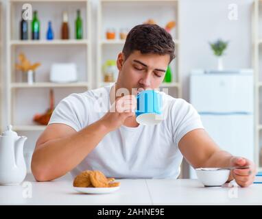 The man falling asleep during his breakfast after overtime work Stock Photo
