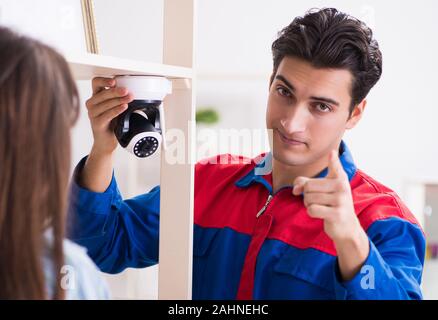 The client getting securty camera installed at home by contractor Stock Photo