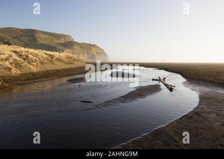 The river, black sand, dunes and mountains of Karekare Beach in West Auckland, New Zealand. Stock Photo