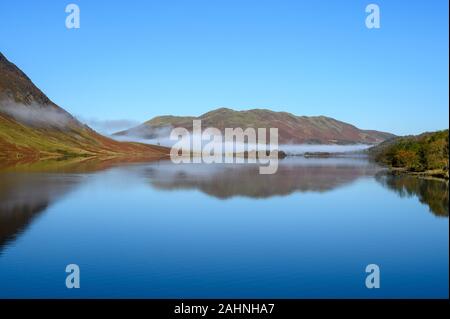 View across Crummock Water in the Lake District looking towards Low Fell. A bank of mist lies at the top of the lake Stock Photo