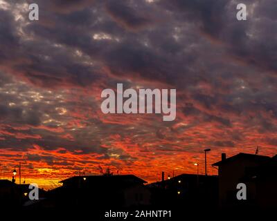 Beautiful colorful sunset over the roofs of a Tuscan village with dramatic sky Stock Photo