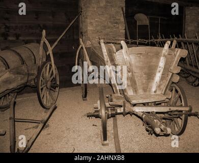 An old carriage that binds to a horse. The plow and blade are loaded on the carriage. Stock Photo