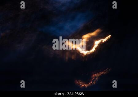 Splash of Dripping Orange Light on Dark Midnight Background Stock Photo