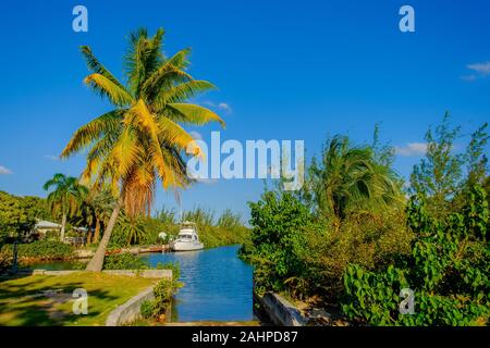 Grand Cayman, Cayman Island, Jan 2019, boat moored in a residential area on a canal leading to the Caribbean Sea in West Bay Stock Photo