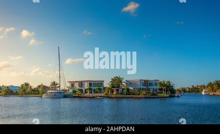 Grand Cayman, Cayman Islands, Jan 2019, boat moored in a residential area at sunset on a canal leading to the Caribbean Sea in West Bay Stock Photo