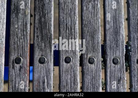 A row of nails hold wooden planks in place Stock Photo