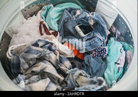 Smartphone in washing machine,Forgotten cell phone in pocket, pant or shirt Stock Photo