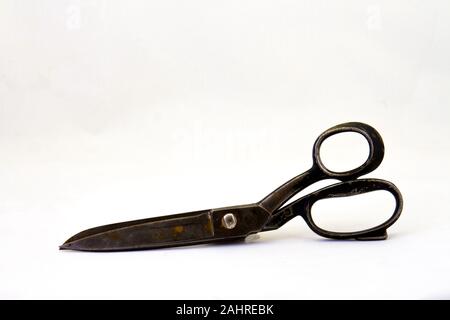Old and worn pair of large black rusted scissors isolated on a white background image with copy space in horizontal format Stock Photo