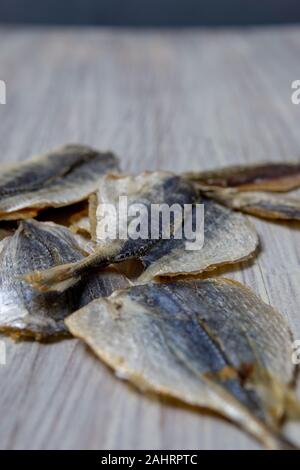 Salted fish lying on a wooden table Stock Photo