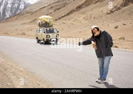 Travelers thai women travel visit and hitchhike vehicle on Srinagar highway at Leh Ladakh while winter season in Jammu and Kashmir, India Stock Photo