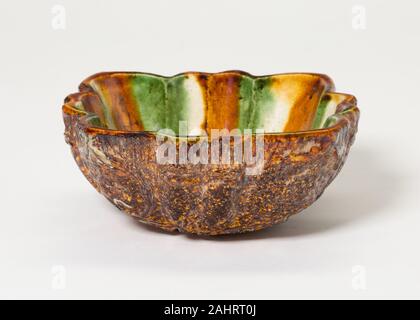 Lobed Bowl with Foliate Medallions. 700 AD–750 AD. China. Earthenware with three color (sancai) lead glazes and underglaze molded decoration Stock Photo