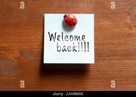 a colored memo sheet with writing  welcome back Stock Photo