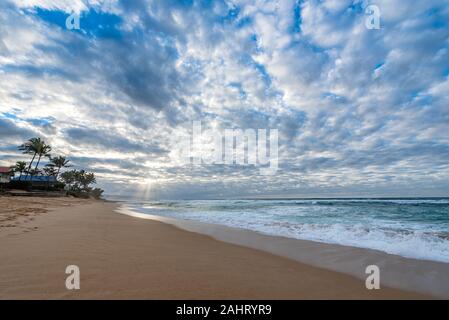 Rays of sunlight shining through a vast sunset sky over Sunset Beach on the north shore of Oahu, Hawaii, USA Stock Photo