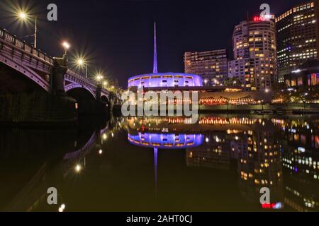 The bright lights and colours of Melbourne's Southbank reflected in the still waters of the Yarra River on a dark night Stock Photo