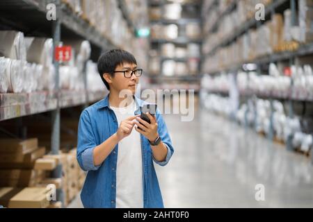Portrait Asian men, staff, product counting Warehouse Control Manager Standing, counting and inspecting products in the warehouse Stock Photo