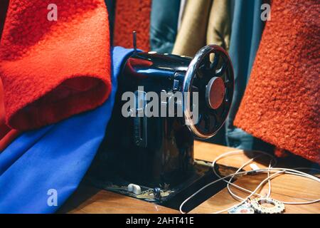 Sewing machine among clothes. Hobbies or sewing or craft. Stock Photo