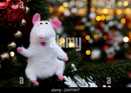 White knitted toy rat on background of fir branches and golden lights, New Year card. Chinese Year of Rat, Zodiac symbol 2020 Stock Photo
