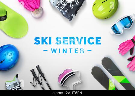 Ski service winter text surrounded by ski and snowboard equipment. Top view, flat lay Stock Photo
