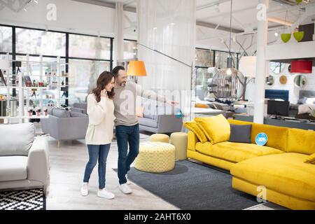 Two people discussing furniture models in a modern furniture shop Stock Photo