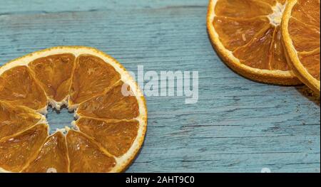 Dried Orange Slices. Hand dried and dehydrated orange slices on a wooden turquoise wooden surface.  Room to write. Stock Image. Stock Photo