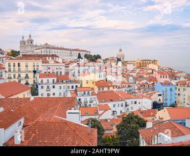 Lisbon panoramic view. Colorful walls of the buildings of Lisbon, with orange roofs and the Church of Sao Vicente of Fora in the background. Sunny day Stock Photo