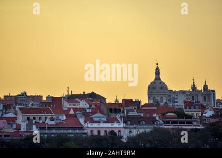Lisbon skyline view. Colorful walls of the buildings of Lisbon, with orange roofs and the Basílica da Estrela at sunset. Travel and real estate concep Stock Photo