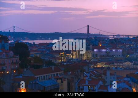 Lisbon panoramic view. Colorful walls of the buildings of Lisbon, with orange roofs and the 25th of April bridge in the background, at sunset. Travel Stock Photo