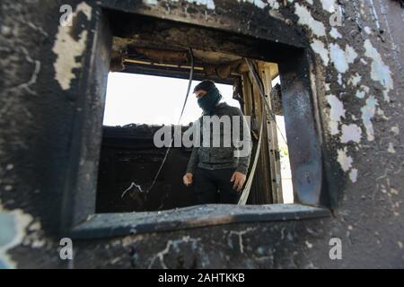 Baghdad, Iraq. 01st Jan, 2020. A protester stands inside a burned checkpoint during the sit-in against deadly US airstrikes on sites of a Shiite militia in front of the US embassy. Iraqi mourners on Tuesday stormed the building of the US embassy in Baghdad's heavily fortified Green Zone. Credit: Ameer Al Mohmmedaw/dpa/Alamy Live News Stock Photo